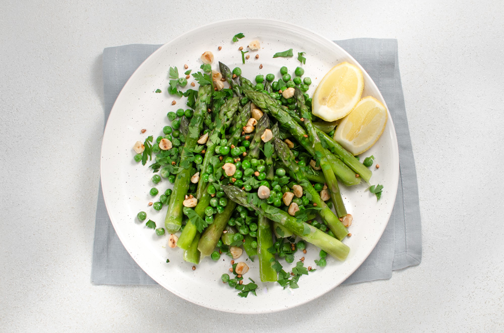 It's the British asparagus season - make the most of it with this very simple combination: fresh asparagus from local fields and fresh peas from a pod, boiled and then quickly braised in butter, with lemon herbs and hazlenuts and kasha for a bit of crunch.
