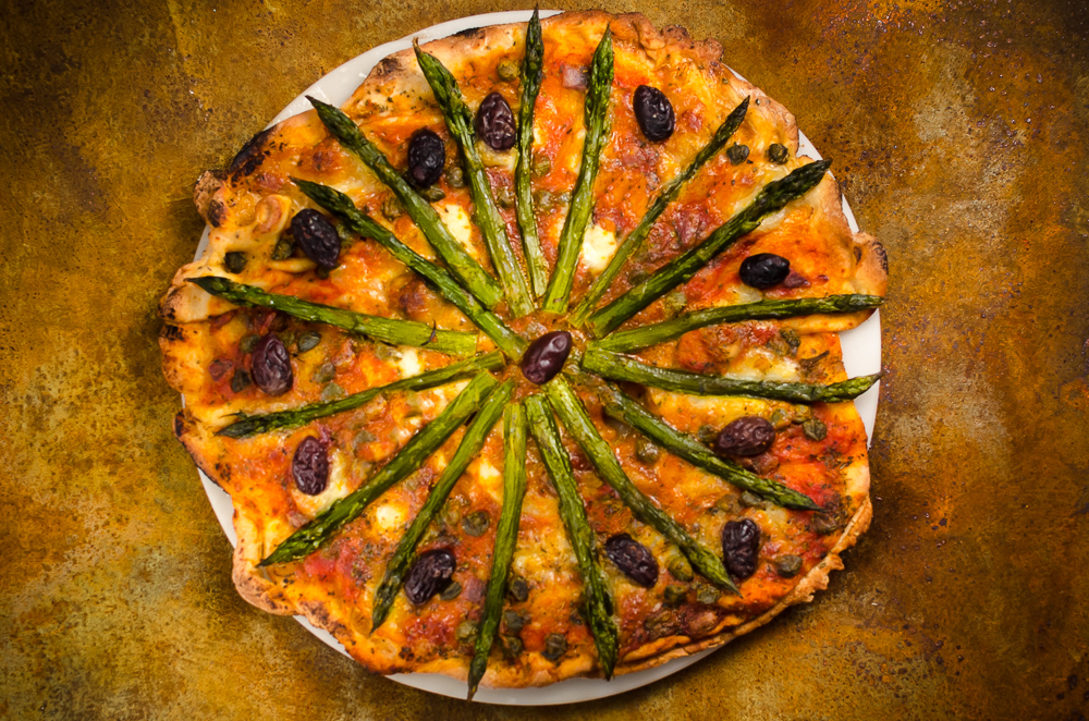 This recipe matches asparagus with a deconstructed puttanesca sauce. Surprisingly, this really works - the asparagus stands up well to the robust pizza flavours.